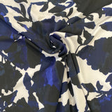 A polyester jersey with a white background and large floral splash pattern in navy and black. Kayes Textiles fabrics