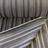 A stretch denim fabric in a charcoal colour with black stripes running throught it. Kayes Textiles Fabrics