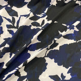 A polyester jersey with a white background and large floral splash pattern in navy and black. Kayes Textiles fabrics