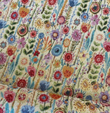 A natural coloured heavy tapestry fabric with coloured flowers all over . Kayes Textiles Fabrics.