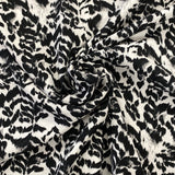 A crepe fabric with a black and white animal style print. Kayes Textiles fabric