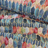A heavy tapestry fabric with a geometric design in blues and reds with gold outlining. Kayes Textiles Fabrics.