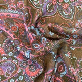 A sheer chiffon fabric with a purple and blue paisley design all over. Kayes Textiles Fabric
