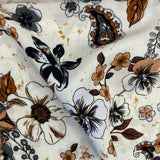 A floaty viscose fabric with a black floral and paisley design on a cream background Kayes Textiles Fabrics