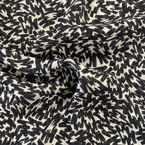 A chiffon fabric with an all over black and white abstract design. Kayes Textiles fabrics.