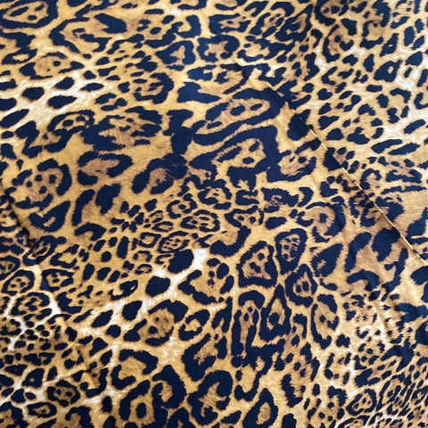 A gold cotton with black animal print design all over. Kayes Textiles Fabrics.