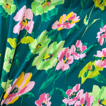 A green polyester jersey with large pink, yellow and green flowers. Kayes Textiles fabrics