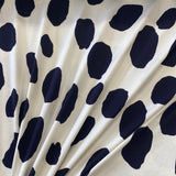 A viscose jersey fabric in white with large navy irregular spots on it. Kayes Textiles Fabric