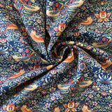 A navy background cotton with a symmetrical bird and floral design. Kayes Textiles Fabrics.
