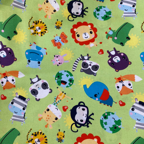 A lime green cotton with cartoon aniamls in bright colours randomly scattered over the fabric. Kayes textiles Fabrics. 