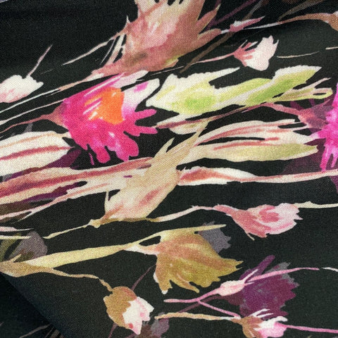A floaty viscose fabric with bursts of pink flowers and shadows of flowers on a black  background Kayes Textiles Fabrics