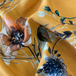 A floaty viscose fabric with a mix of flowers and stems on a gold background  Kayes Textiles Fabrics