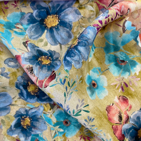 a floaty viscose fabric with a mix of blue and pink water colour flowers on a sage background Kayes Textiles Fabrics