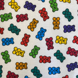 A white fabric with different coloured gummy bears all over. Kayes Textiles Fabrics.
