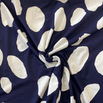 A viscose jersey fabric in navy with large white irregular spots in white on it. Kayes Textiles Fabric
