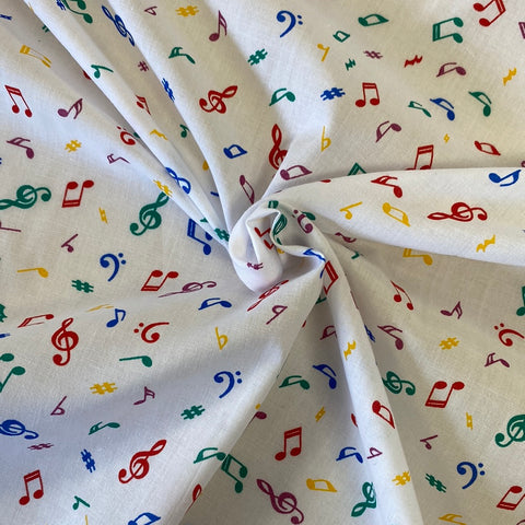 A white fabric with small coloured music notes all over. Kayes Textiles Fabrics