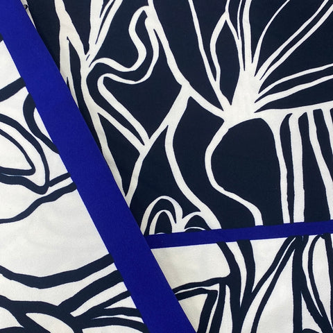 A crepe jersey with a double border. Dark navy centre with white abstract design then white borders with navy abstract design. A cobalt blue strip sperates the border sections. Kayes Textiles fabrics