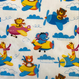 A white fabric with different animal characters flying in aeroplanes. Kayes Textiles Fabrics