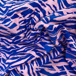 A jersey fabric with a royal blue and pink zebra style animal print design. Kayes Textiles fabrics